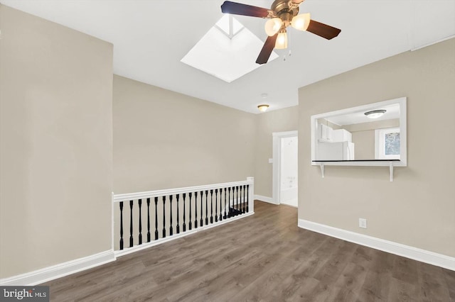 empty room with hardwood / wood-style floors and a skylight