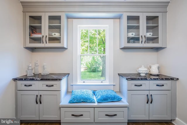 bar featuring gray cabinetry and dark stone countertops