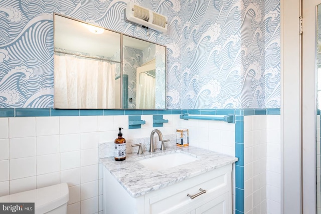 bathroom featuring vanity, toilet, curtained shower, and tile walls