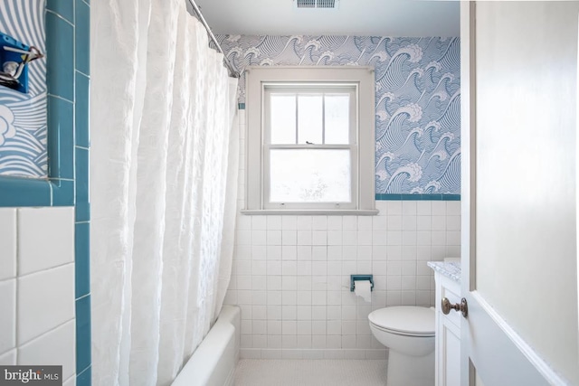 full bathroom featuring vanity, toilet, shower / tub combo, and tile walls