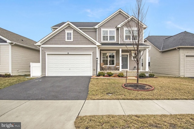 view of front of home featuring a garage, a front lawn, and a porch