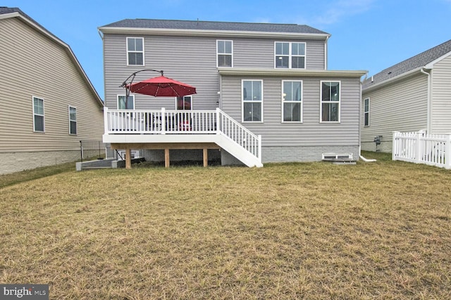 rear view of house featuring a deck and a lawn