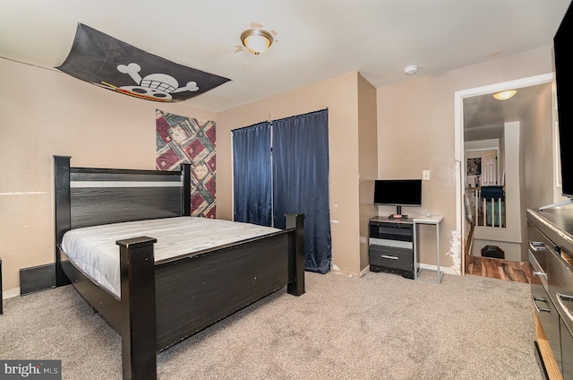 bedroom with light colored carpet and baseboards