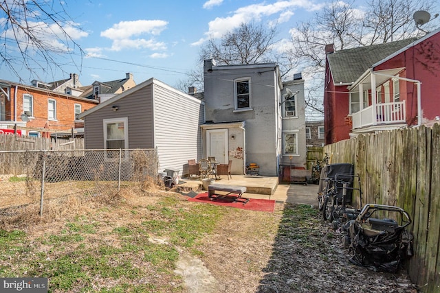 back of property featuring a patio area and fence