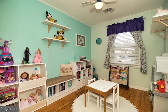 rec room featuring crown molding, ceiling fan, and dark hardwood / wood-style floors