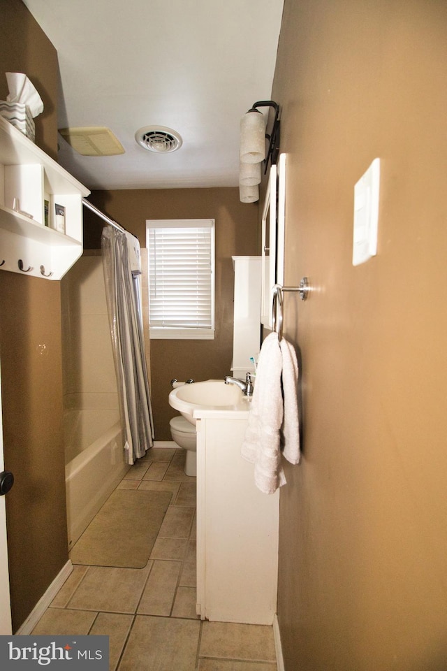 full bathroom with shower / tub combo with curtain, tile patterned floors, toilet, and vanity