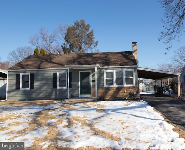 snow covered property featuring a carport