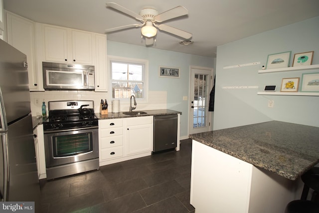 kitchen with appliances with stainless steel finishes, sink, decorative backsplash, and white cabinets