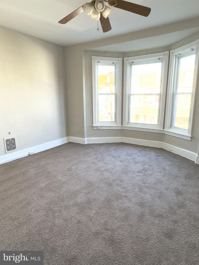 carpeted spare room with ceiling fan