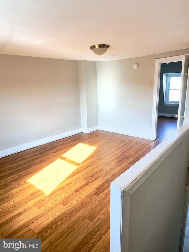 unfurnished room with wood-type flooring