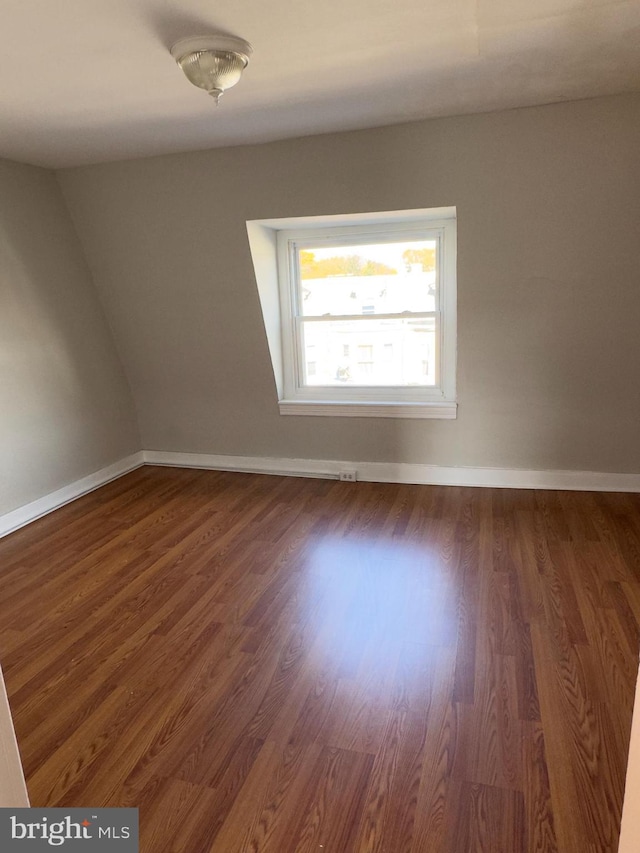 unfurnished room with dark wood-type flooring