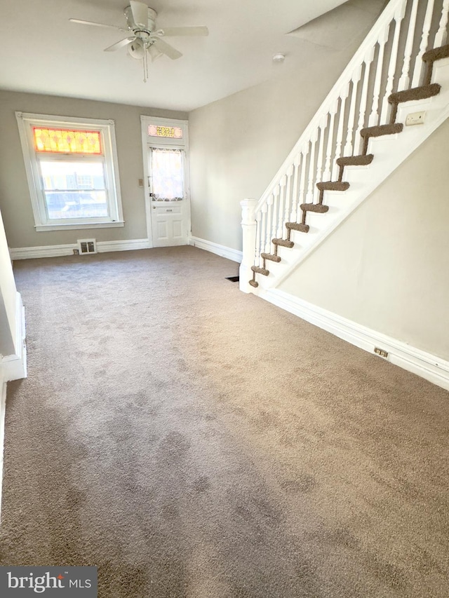 carpeted foyer entrance with ceiling fan