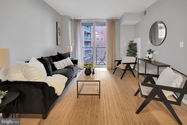 living room featuring floor to ceiling windows and light wood-type flooring