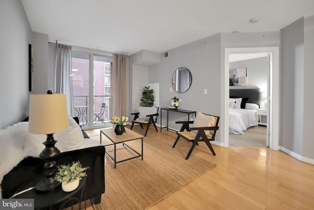 living room featuring a wall of windows and hardwood / wood-style floors