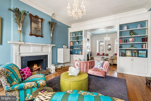 living area featuring crown molding, a chandelier, built in shelves, and hardwood / wood-style flooring