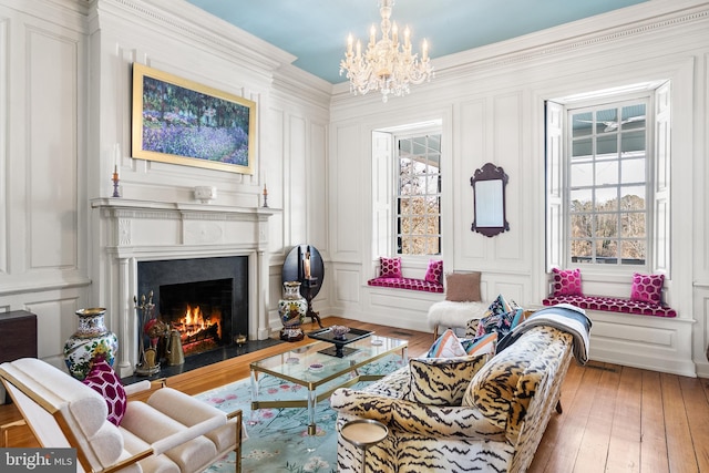 sitting room featuring hardwood / wood-style flooring, ornamental molding, and a chandelier