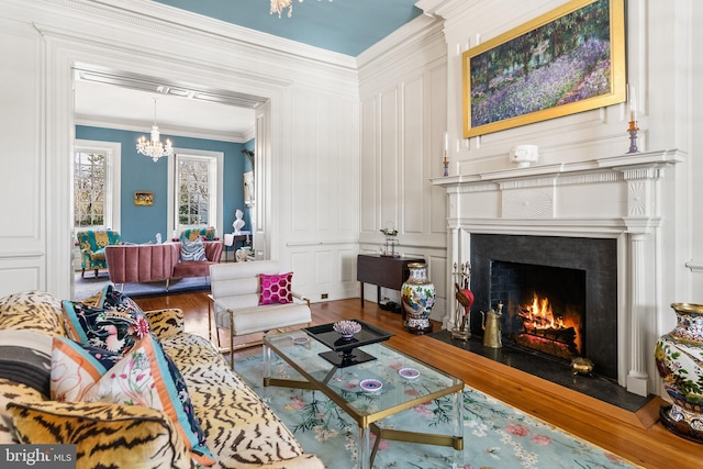 living room featuring crown molding, hardwood / wood-style floors, and a notable chandelier