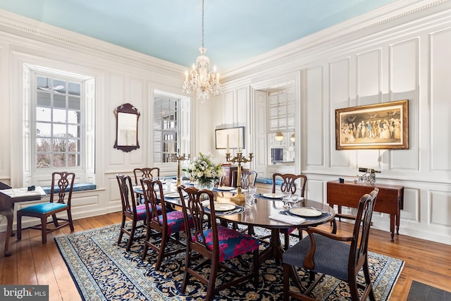 dining room featuring ornamental molding, hardwood / wood-style floors, and a chandelier