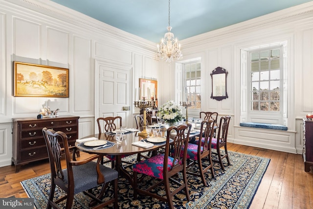 dining space featuring an inviting chandelier, crown molding, and hardwood / wood-style floors