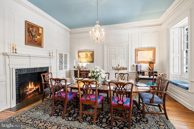 dining space featuring crown molding, light hardwood / wood-style flooring, and a notable chandelier