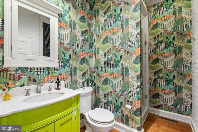 bathroom with vanity, hardwood / wood-style flooring, and toilet