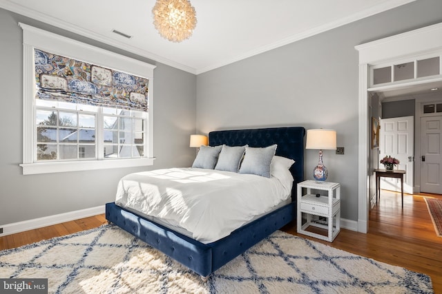 bedroom with hardwood / wood-style floors and ornamental molding