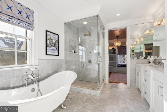 bathroom featuring crown molding, vanity, shower with separate bathtub, and tile walls