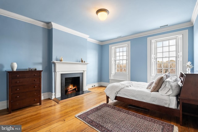 bedroom with wood-type flooring and ornamental molding