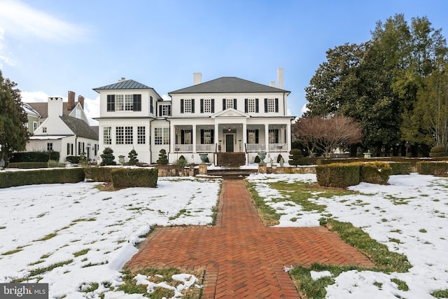 snow covered property featuring a porch