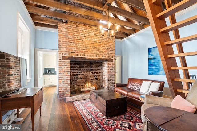 living room featuring hardwood / wood-style flooring, an inviting chandelier, beam ceiling, a towering ceiling, and a fireplace