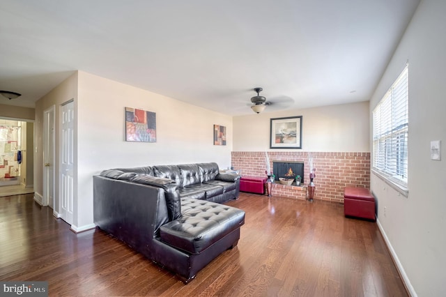 living room featuring hardwood / wood-style flooring, ceiling fan, and a fireplace