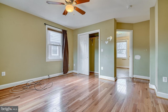 unfurnished bedroom with light hardwood / wood-style floors, a closet, and ceiling fan