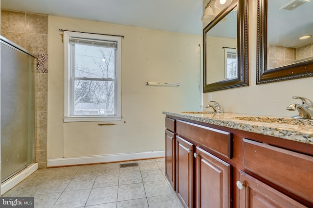 bathroom featuring tile patterned flooring, vanity, and walk in shower