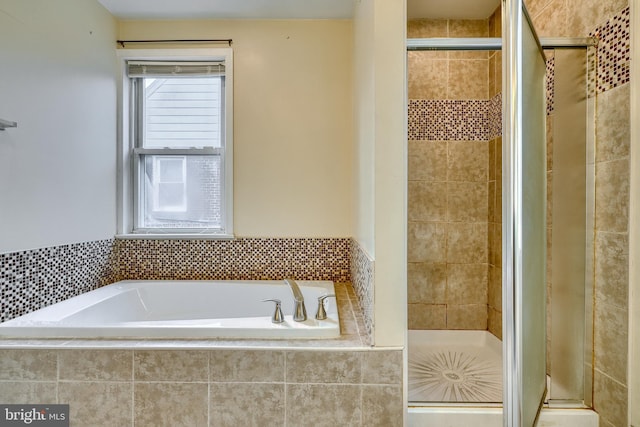 bathroom featuring shower with separate bathtub