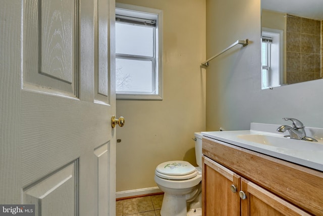 bathroom featuring vanity, toilet, tile patterned flooring, and a wealth of natural light