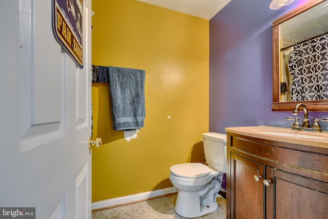 bathroom featuring vanity, toilet, and tile patterned flooring