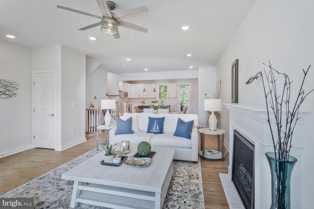 living room with ceiling fan and light hardwood / wood-style flooring