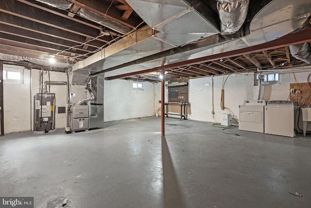 basement with heating unit, washing machine and dryer, and water heater