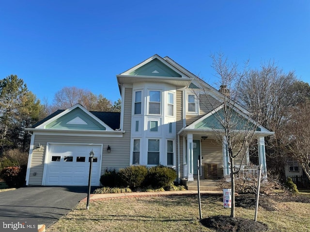 view of front of property featuring a garage, covered porch, and a front yard