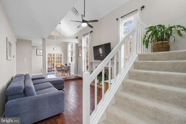 stairs featuring hardwood / wood-style flooring, lofted ceiling, and ceiling fan