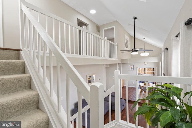 stairway with wood-type flooring, high vaulted ceiling, and ceiling fan