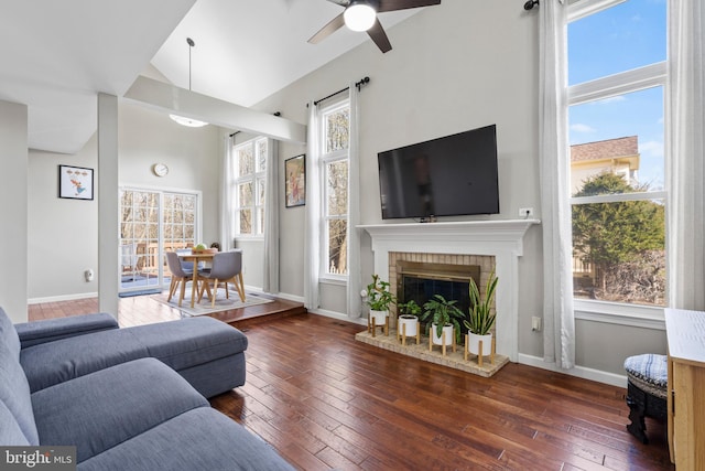 living room featuring a brick fireplace, dark hardwood / wood-style floors, and ceiling fan