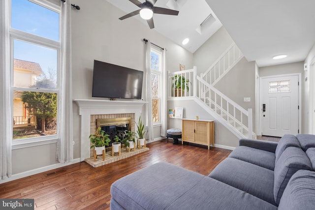 living room with dark hardwood / wood-style floors, a wealth of natural light, and a fireplace