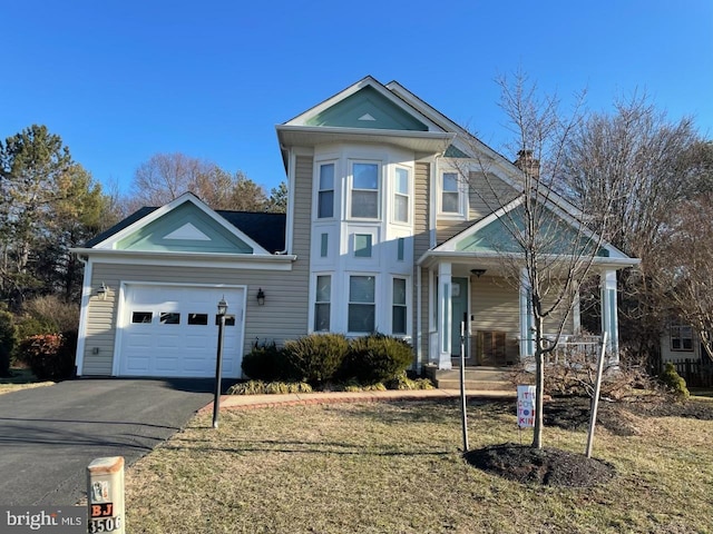 view of front of property with a garage, a front yard, and covered porch