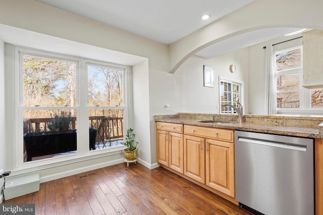 kitchen with light brown cabinetry, dishwasher, sink, dark hardwood / wood-style flooring, and light stone counters