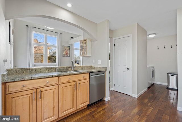 kitchen featuring sink, dark hardwood / wood-style floors, light stone countertops, washer / clothes dryer, and stainless steel dishwasher