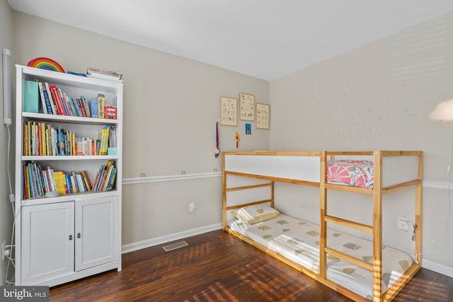 bedroom with dark hardwood / wood-style floors