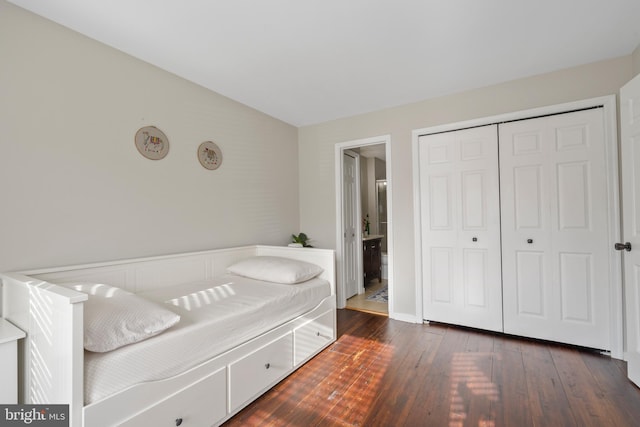 bedroom with ensuite bathroom, vaulted ceiling, dark hardwood / wood-style floors, and a closet