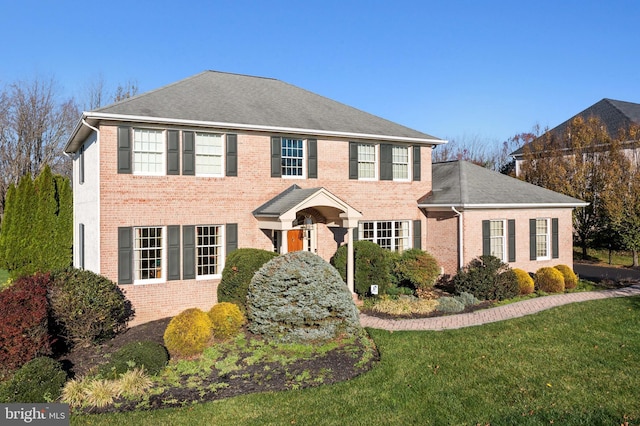 colonial inspired home with a front lawn