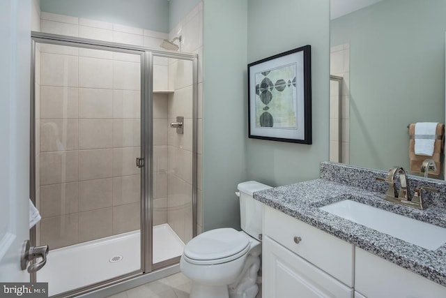 bathroom featuring vanity, toilet, and a shower with door